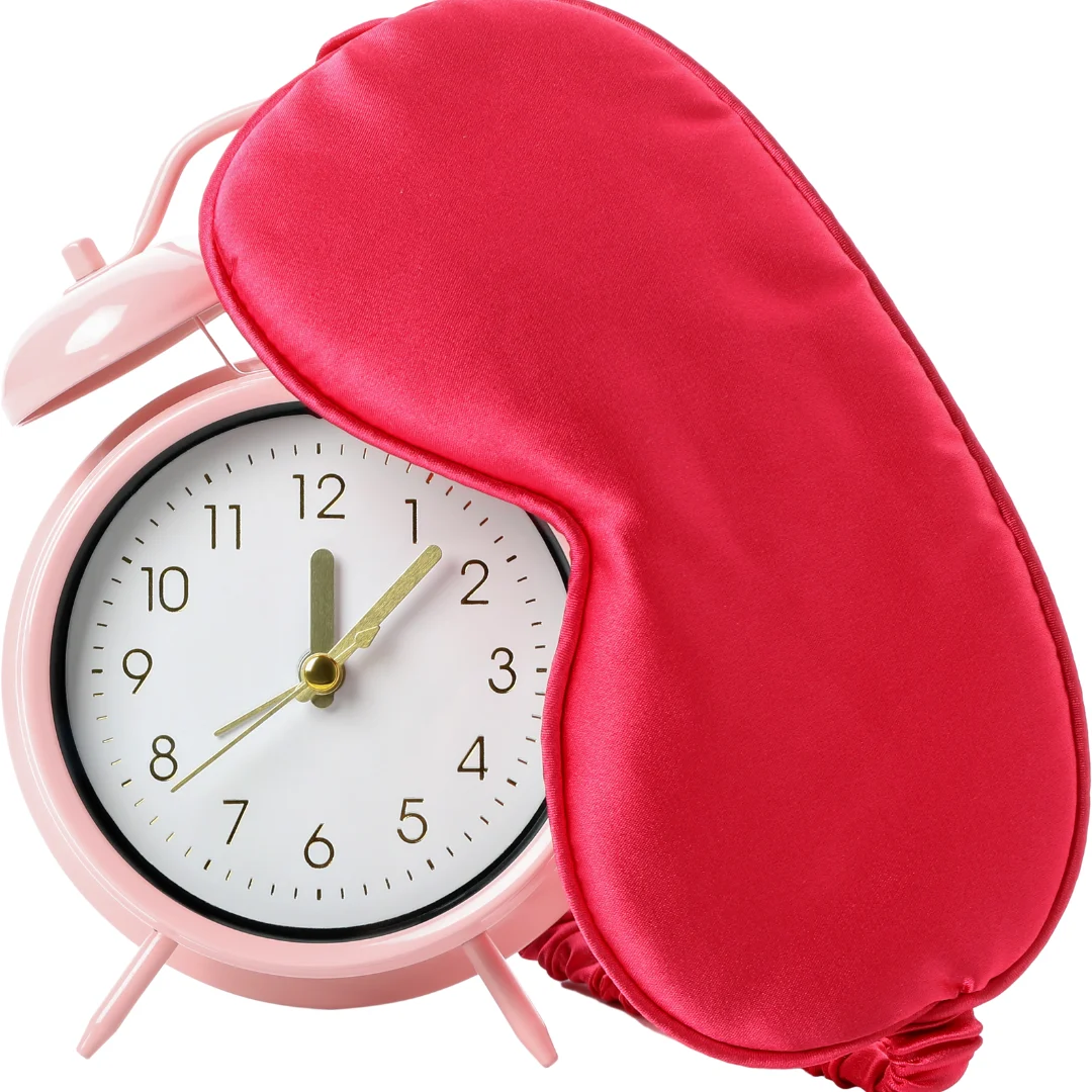 Clock and sleep mask on a bed